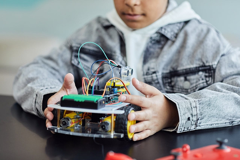 boy holding a toy with electric wires and wheel